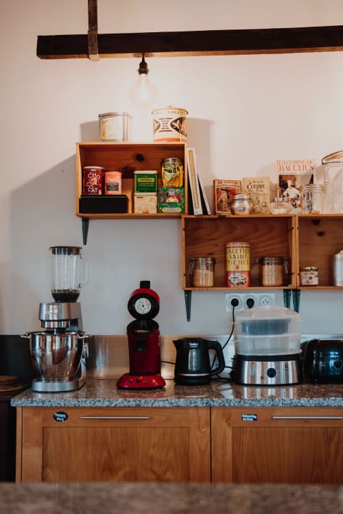 Baccara Lodge kitchen counter with wooden shelves, vintage appliances, and French cooking books in Arengosse