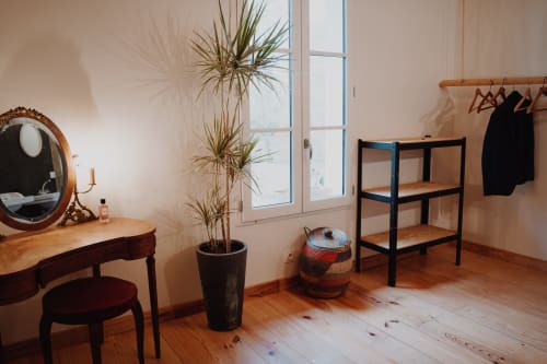 Elegant bedroom at Baccara Lodge in Arengosse with vanity mirror, potted plants, wooden shelving, and clothing rack
