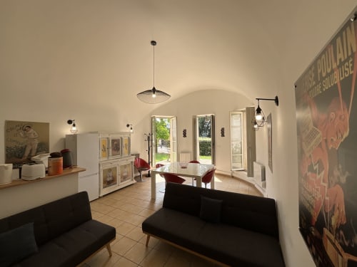 Locacharme cottage sitting area with black sofa, dining table, arched ceiling and garden view doors in Blois