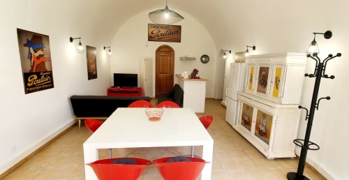 Gemütlicher Speisebereich des Locacharme Cottages in Blois mit roten Stühlen, Vintage-Poulain-Deko und Sitzbereich