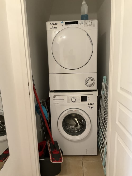 Stacked washer and dryer in laundry closet at Locacharme Gîte La Chocolaterie cottage in Blois, France