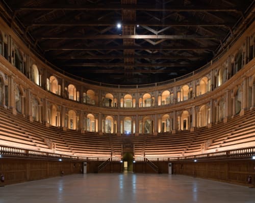 Interno del teatro rinascimentale di Parma con balconate curve, sedute in legno e architettura ornamentale