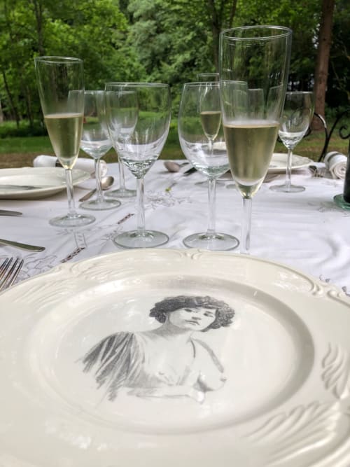 Élégante mise en table en plein air au Domaine de l'Ocrerie avec des flûtes à champagne et une assiette décorée du  portrait de Colette à Pourrain, France