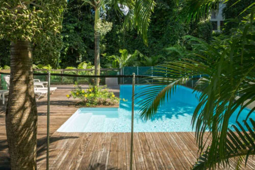 la belle piscine de la résidence Les Jardins de l'espérance à Bouillante, au milieu des grands arbres tropicaux de la forêt de l'Espérance, pour une expérience zen proche de la nature