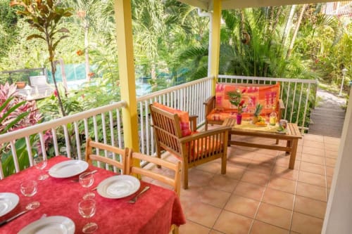 Jolie terrasse colorée de l'hébergement VertMadras, pour 2 à 4 personnes, vue sur la piscine et le jardin tropical, pour un séjour au calme