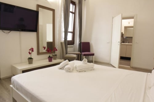 Camera Matrimoniale Moderna al Bronze Horse Affittacamere a Firenze con letto bianco, TV e vista sulla città