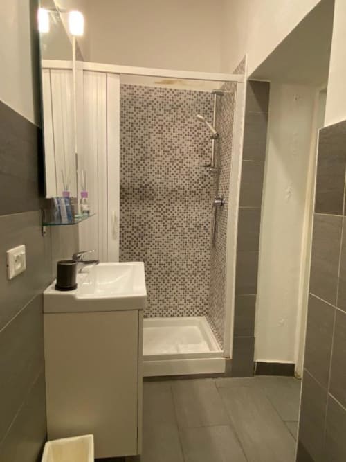 Bagno moderno nella struttura B&B di Firenze con doccia walk-in, lavabo bianco e piastrelle grigie