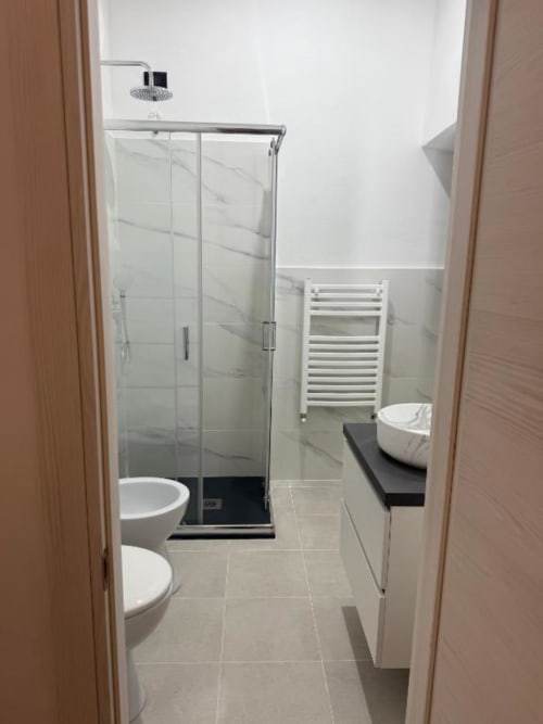 Bagno moderno con doccia walk-in, piastrelle in marmo, wc e scaldasalviette riscaldato al Bronze Horse Florence B&B