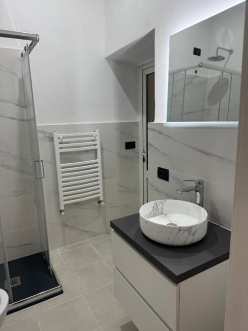 Bagno moderno presso Bronze Horse Affittacamere Firenze con lavabo in marmo, soffione pioggia e scaldasalviette elettrico