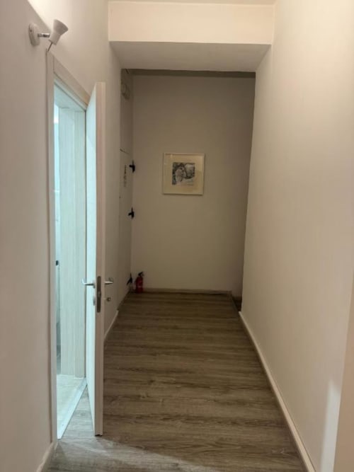 Corridoio nella camera doppia del Bronze Horse Affittacamere, Firenze con pavimento in legno e vista sulla porta della corte interna
