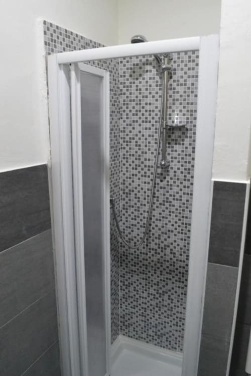 Moderno box doccia con piastrelle a mosaico e cornice bianca nel bagno di Bronze Horse Affittacamere Firenze