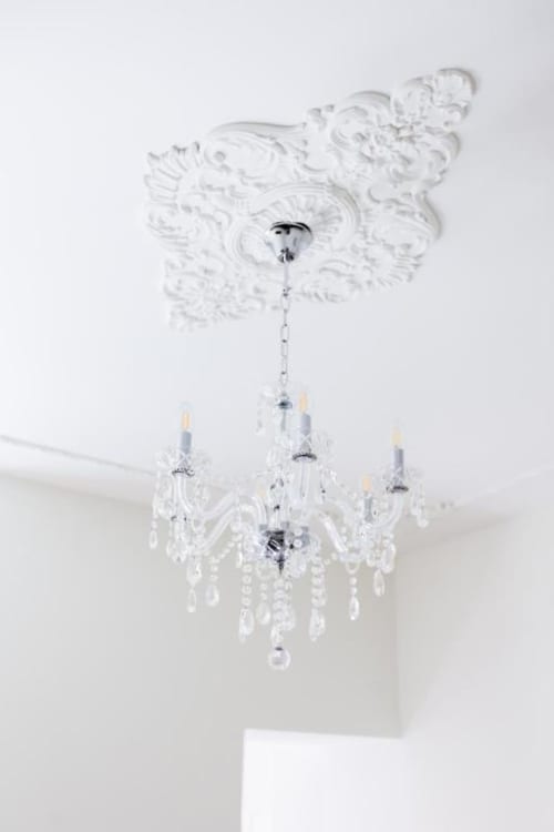 Ornate white crystal chandelier with glass drops hung from decorative ceiling medallion in Suite 5 at Alessia's Place, Como