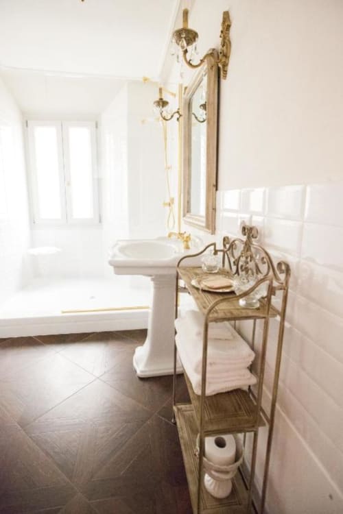 Elegante bagno della Suite 3 di Alessia's Place Como con lavabo su piedistallo, specchio ornato, rubinetteria in ottone e pavimenti in marmo.