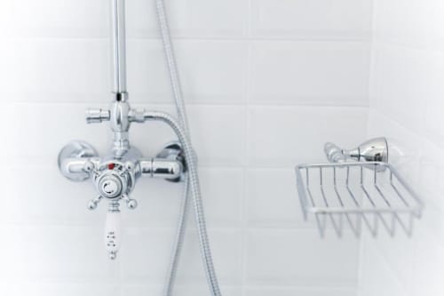 Modern chrome shower fixtures and basket in Alessia's Place bathroom, Como