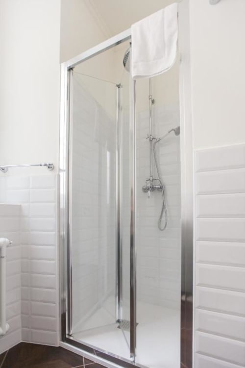 Modern glass shower enclosure with chrome fixtures in Suite 7 bathroom at Alessia's Place, Como