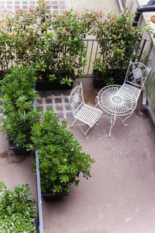 Terrace garden at Alessia's Place Como with potted plants and white wrought iron seating