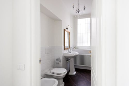 Modern bathroom in Suite 7 at Alessia's Place Como B&B with pedestal sink, bidet, and elegant white tiled walls