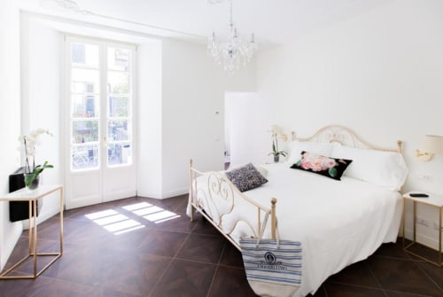 Suite moderna e luminosa ad Alessia's Place Como con letto ornato, lampadario, porte-finestre sulla terrazza e arredamento minimalista