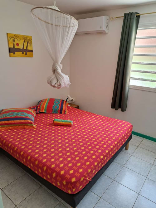 la chambre climatisée et colorée de l'hébergement Ixora pour un sommeil réparateur pendant vos vacances aux jardins de Pointe Noire en Guadeloupe