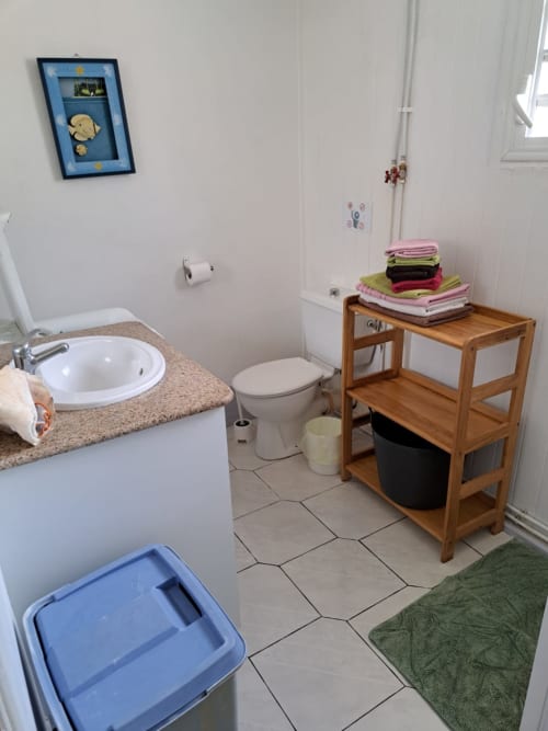 salle de bain du gîte Ixora avec douche, lavabo, toilette et lave linge. Pour des vacances réussies aux Jardins de Pointe Noire en Guadeloupe. Serviettes fournies