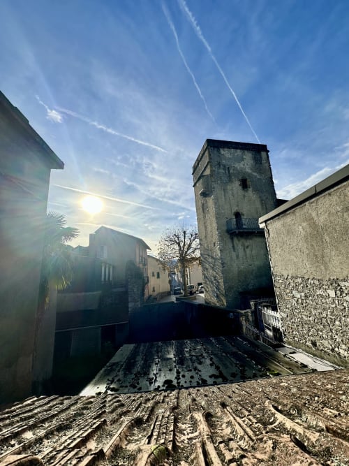 Średniowieczna wieża i zabytkowe kamiienne budynki w centrum Lourdes, widok na hotel Ombre de la Tour