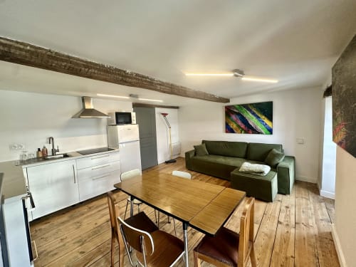 Nowoczesny apartament duplex w Lourdes z otwartą kuchnią, strefą jadalną i zieloną sofą