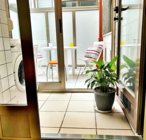 Entrada al balcón del apartamento Chuliña en Baiona con terraza, sillas blancas y maceta