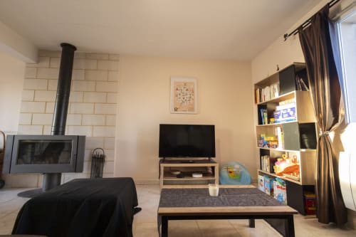 Salon de cottage à Châteaudun avec cheminée, TV, bibliothèque et vue sur le jardin