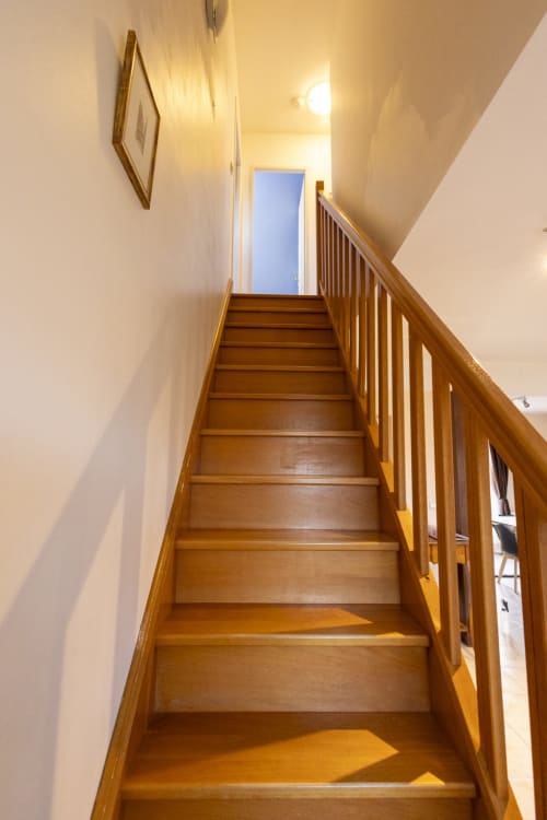 Escalier en bois avec rampe menant à l'étage du gîte Accolade à Châteaudun
