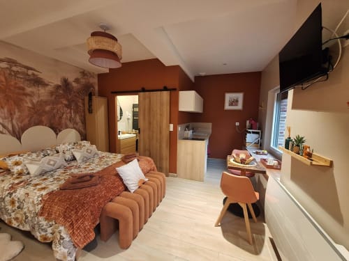 Chambre douillette à La Cour d'Hortense avec murs en terre cuite, mobilier en bois, TV et équipements modernes