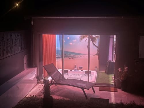 Intérieur de gîte moderne avec fauteuil lounge et portes coulissantes ouvrant sur la vue du jardin du Gîte du Miroir Domérat, France