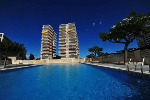 Edificio residencial frente al mar en Benicàssim con piscina y torres gemelas con vistas al agua azul cristalina