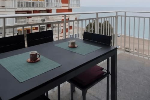 Balcón de apartamento frente al mar con mesa de comedor, vista al océano y comodidades modernas en Benicàssim