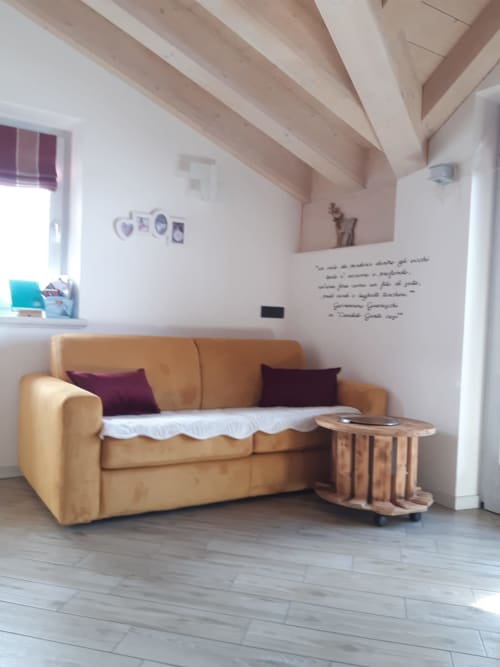 Accogliente appartamento di montagna ad Al Dos Livigno con divano in pelle color nocciola, travi in legno e vista sulle Alpi