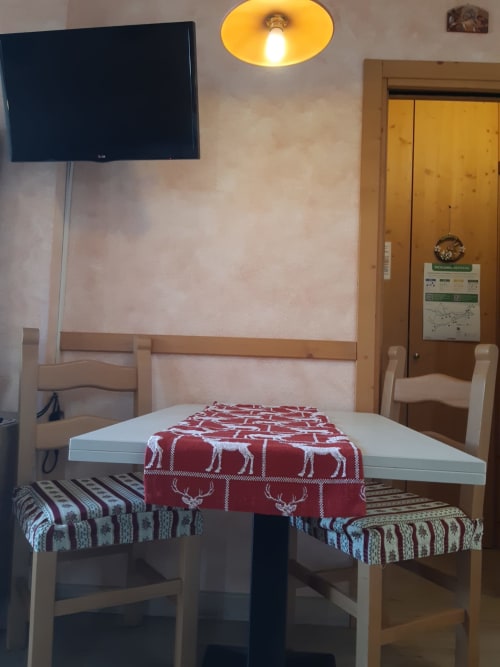 Appartamento Al Dos a Livigno con tavolo, sedie, decorazioni montane e lampada a soffitto