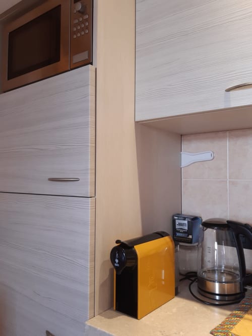 Moderno angolo cucina ad Al Dos Livigno con macchina espresso gialla, bollitore e elettrodomestici in appartamento