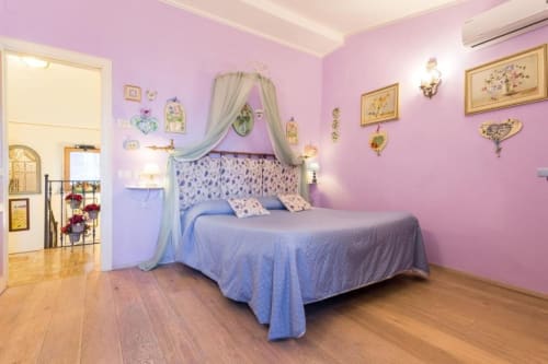 Camera da letto rosa con letto a baldacchino blu presso Dormire Assisi B&B, Assisi Italia