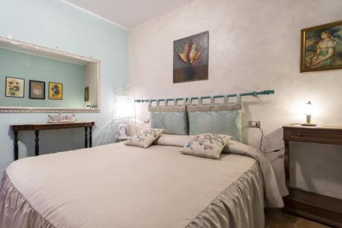 Camera elegante al Dormire Assisi B&B con biancheria crema, accenti turchesi e arredi classici