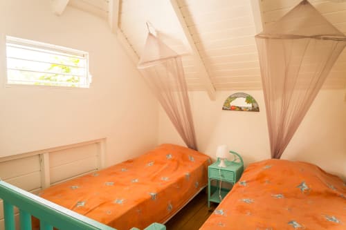Mezzanine climatisée avec 2 lits simples et moustiquaires, permet des nuits reposantes, aux jardins de l'espérance à Bouillante en Guadeloupe