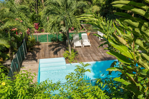 la jolie piscine avec des transats sur le deck pour un moment de détente, entourée de la superbe végétation tropicale, aux jardins de l'espérance à Bouillante en Guadeloupe