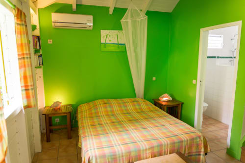 Le gîte climatisé VertMadras pour 2 à 4 personnes, avec sa grande chambre climatisée au rez de chaussée, aux couleurs créoles