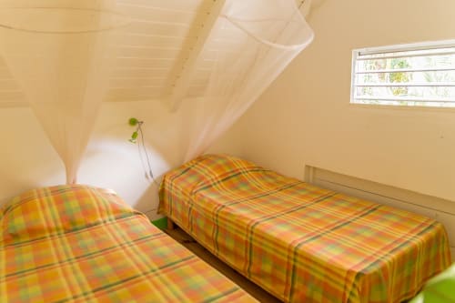 la mezzanine climatisée du gîte VertMadras, avec 2 lits simples et moustiquaires, permettent des nuits fraîches et reposantes à la résidence les jardins de l'espérance à Bouillante en Guadeloupe