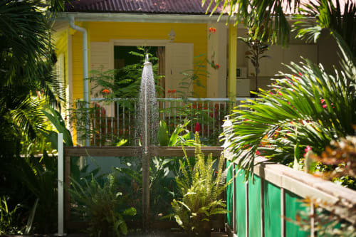 douche extérieure sur le deck de la piscine sécurisée des jardins de l'espérance à Bouillante en Guadeloupe, pour se rincer du sable des plages avant un bain rafraichissant dans la piscine