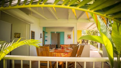 la terrasse ouverte sur la végétation du gîte Mussaenda pour 4 à 6 personnes avec ses 2 chambres climatisées et ses 2 salles de bains, et un grand espace séjour/salle à manger. C'est aux jardins de l'espérance à Bouillante en Guadeloupe