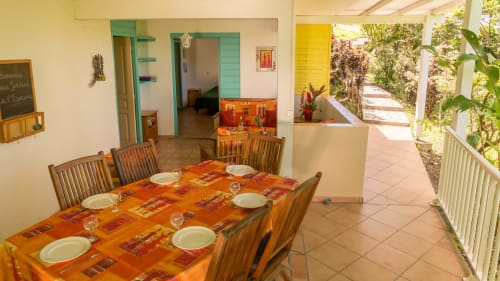la grande terrasse colorée du gîte mussaenda pour 4 à 6 personnes aux jardins de l'espérance à Bouillante en Guadeloupe. Séjour proche de la nature garantit