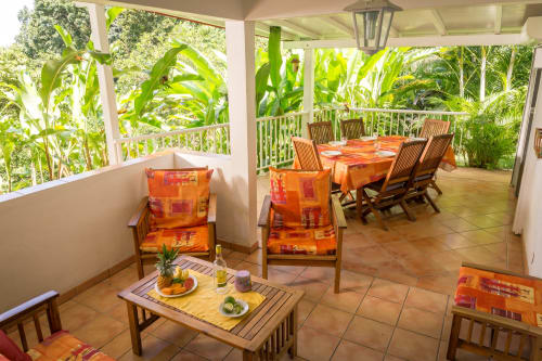 grand espace séjour/ salle à manger du gîte mussaenda 4 à 6 personnes, aux jardins de l'espérance à Bouillante, ouvert sur la végétation du parc paysager