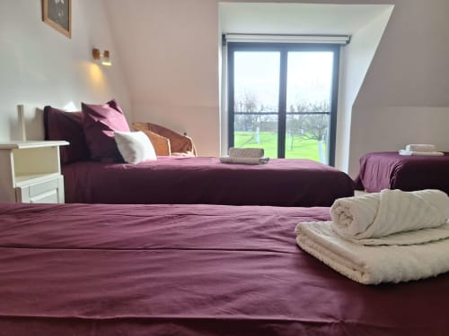 Eines der Zimmer im La Moussette mit Blick auf den Obstgarten Clos Delamare für ein Wochenende inmitten der Natur in der Normandie.