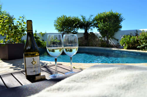 Botella de vino y copas junto a la piscina en La Vista Medina Stays, Medina Sidonia, España