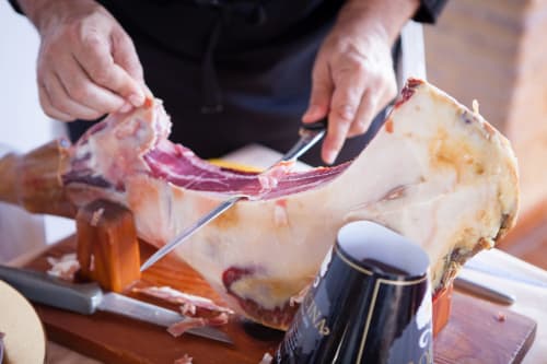 Chef trinchando jamón ibérico en La Vista Medina Stays, Medina Sidonia, España