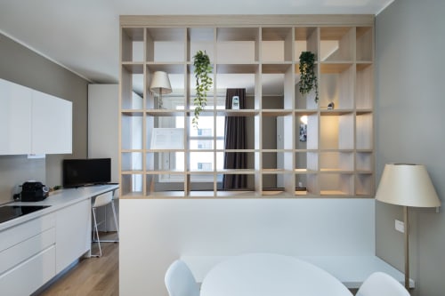 Modernes Mailänder Apartment mit Holzraumteiler, Küche, Essbereich und Stadtblick in den Magnolia Apartments
